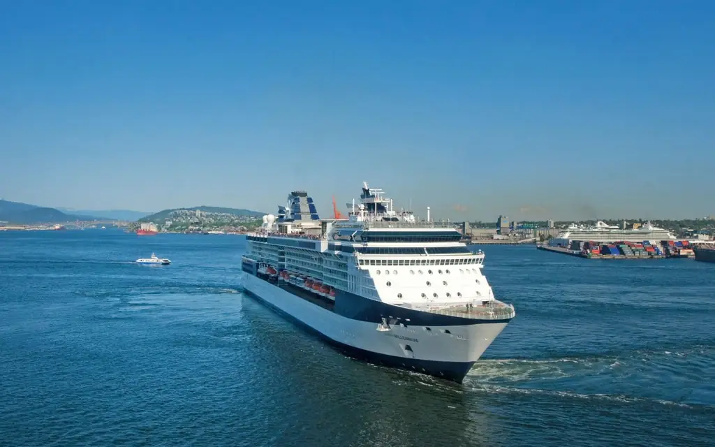 A large cruise ship sailing through calm waters under a clear blue sky, perfect for a relaxing vacation